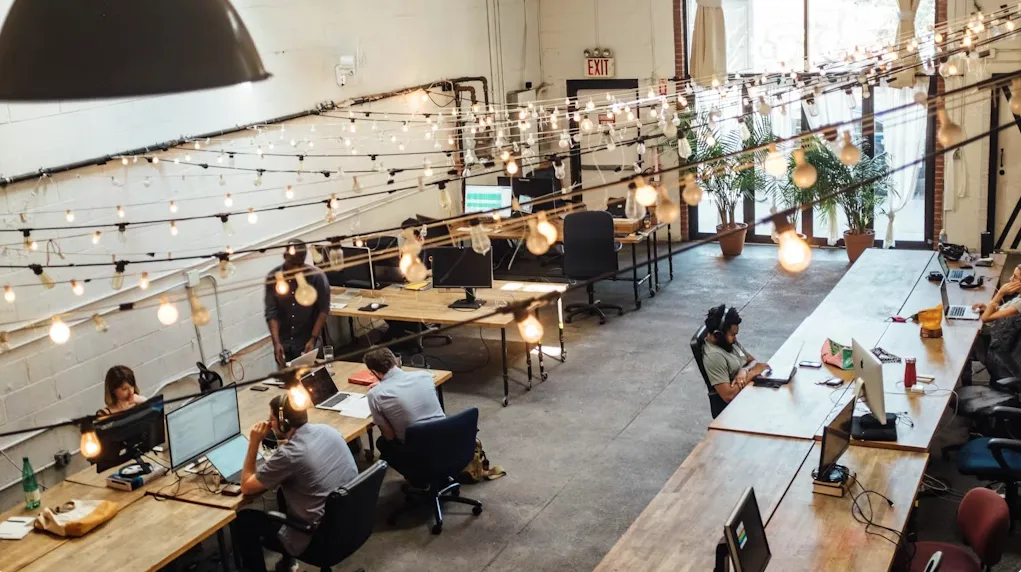 Modern bright co-working space with open desks and meeting pods